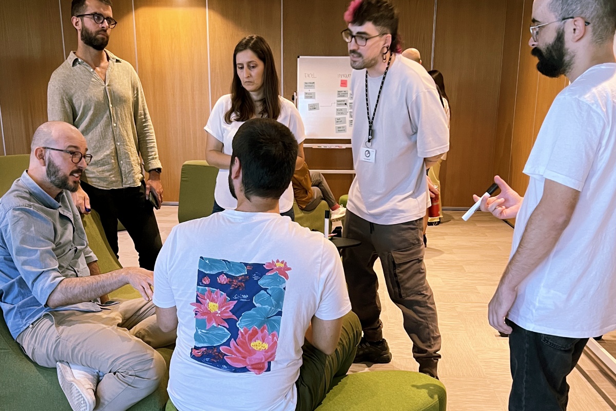 Picture of 6 people in a circle, five listening to one.