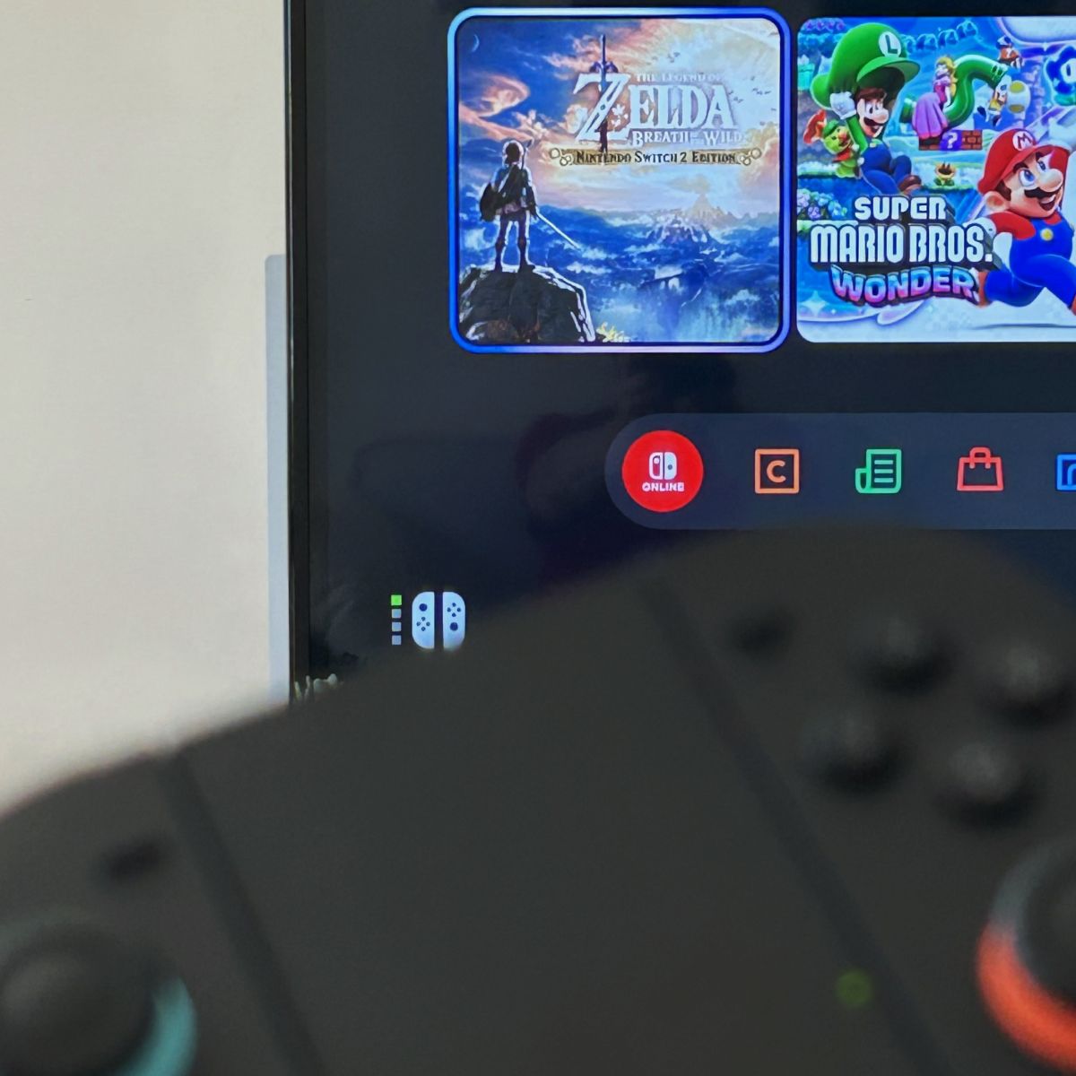 Nintendo switch 2 controler and a TV showing a game selection screen.