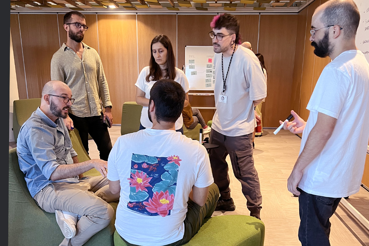 Picture of 6 people in a circle, five listening to one.